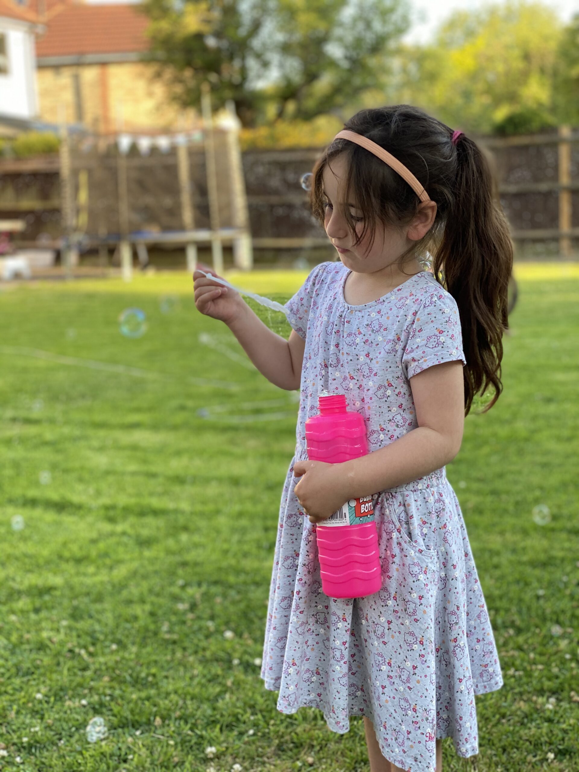 Young child watching bubbles with curiosity outdoors.