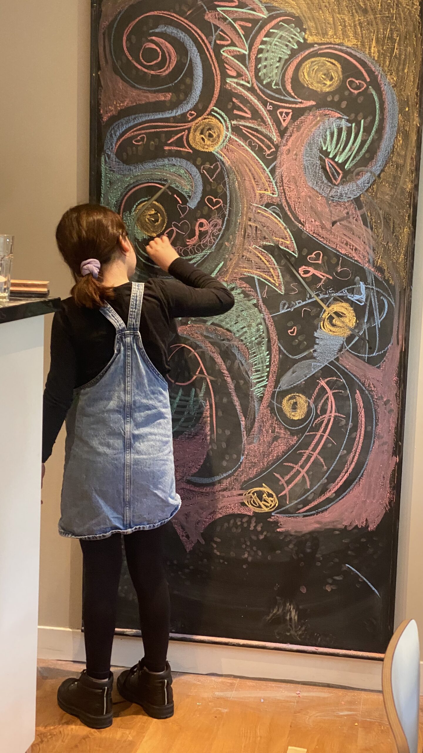 Child absorbed in creating colourful chalk artwork